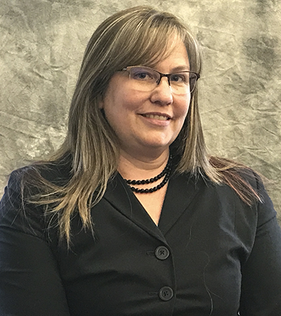 Woman with shoulder legth blonde hair wearing a collared button up shirt