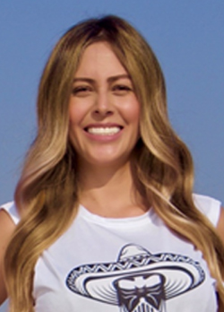 Woman with long brown hair wearing a white tank top with image of sombrero