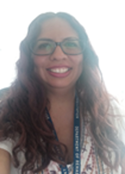 Woman with brown curly hair wearing glasses and red lipstick